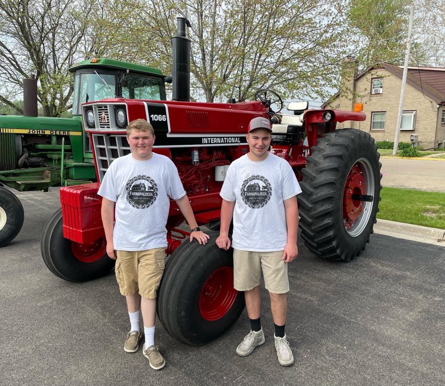 Junior Albert Lawrence and sophomore Brady Shank stand next to a 1066 Interrelation at Farmapalooza where students were able to sit on a tractor and take a picture. In previous years FFA members were able to drive around the block for a parade of tractors. 