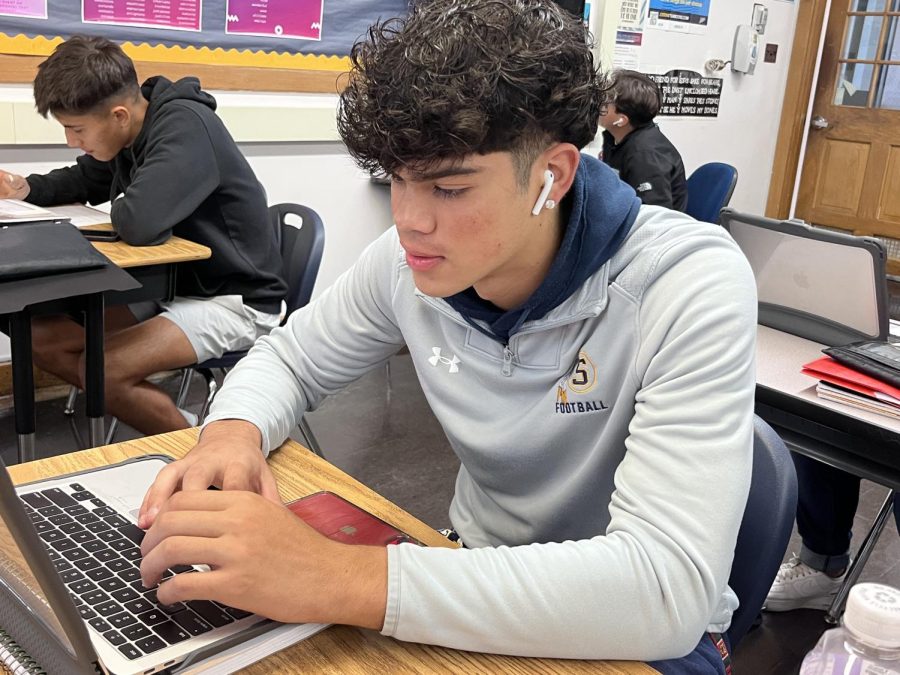 Senior Mateo Vasquez listening to music while working diligently on his yearbook spread. When listening to music, many S.H.S. students choose to listen with AirPods.