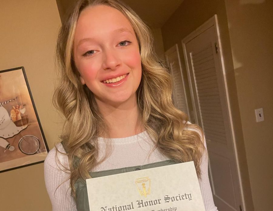 Junior Avery VanOosten poses with her National Honor Society induction paper. The NHS ceremony is held every fall.