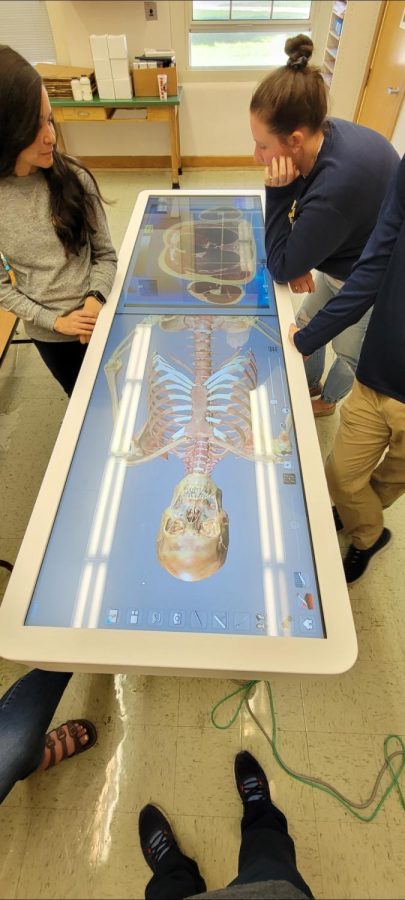 S.H.S. science teachers figure out how to use the anatomy table for the first time. Anatomy and physiology use the table once every week.  