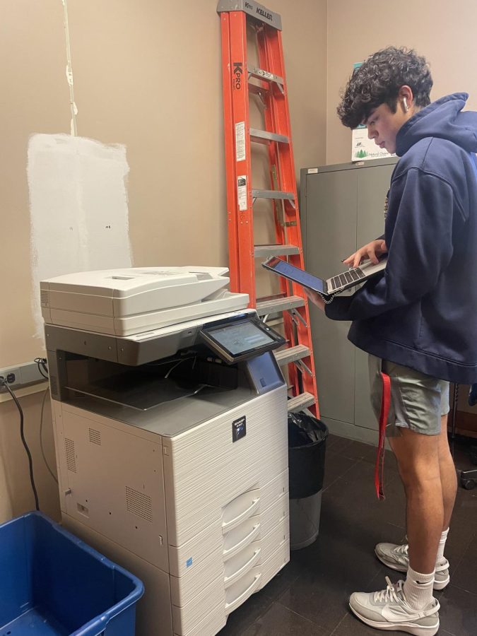 Senior Mateo Vasquez virturally prints his Publications spread. The printer shown in this photo is adjcent to Mr. Johnsons room.   