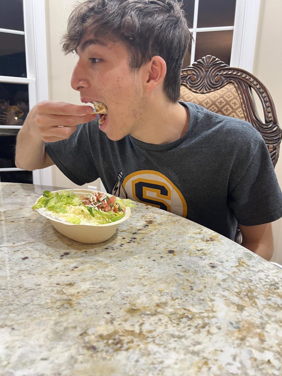 Junior Jubraan Alkhalaf bites into his burrito bowl. Chipotle adds the option to get chips with the order, which is a popular feature.
