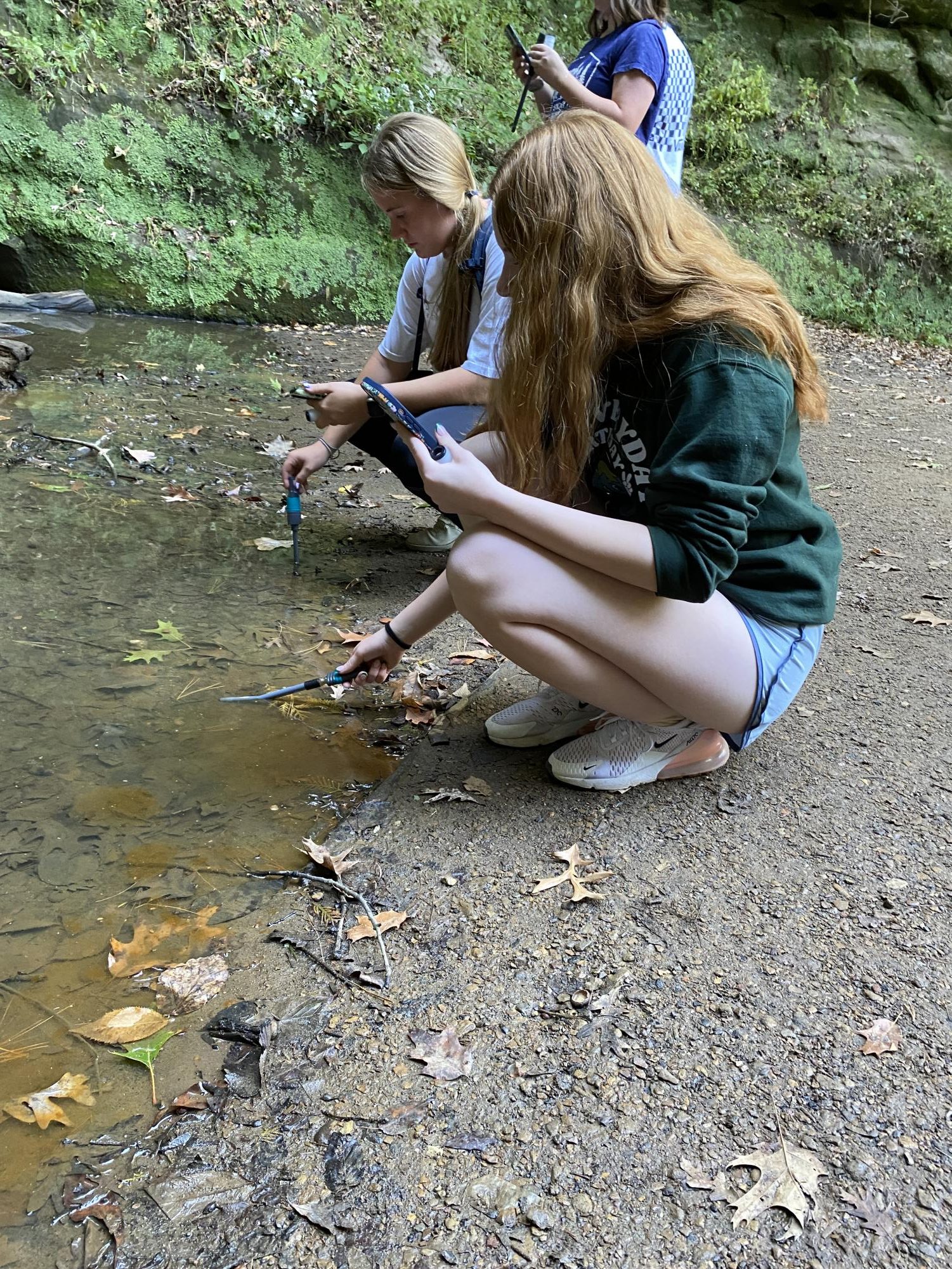 APES students Carlee Hawkins and Ellie Aitken use probes to test the water.